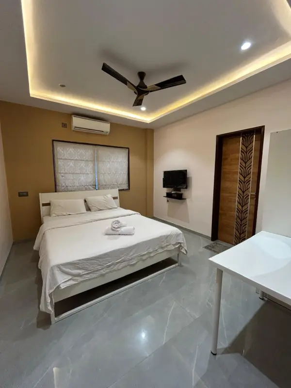 Sirrus Bedroom Minimalist bedroom with wall-mounted TV and large bed - Misty Palace Villa, Lonavala