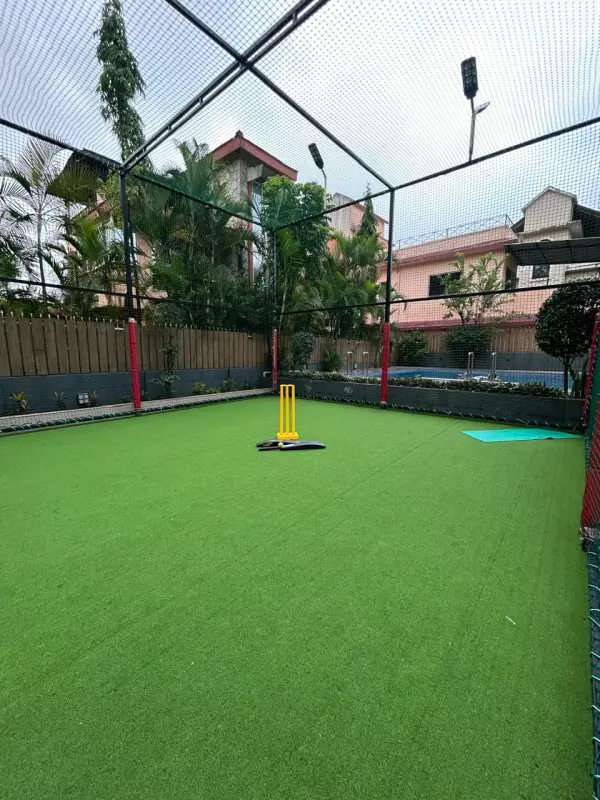 Well-maintained artificial turf with stumps and bat setup - Misty Palace Villa, Lonavala
